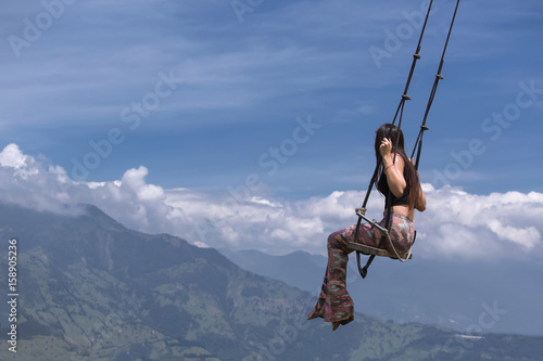 Unknown person swinging at the La casa del Arbol in Banos de Agua Santa, Ecuador