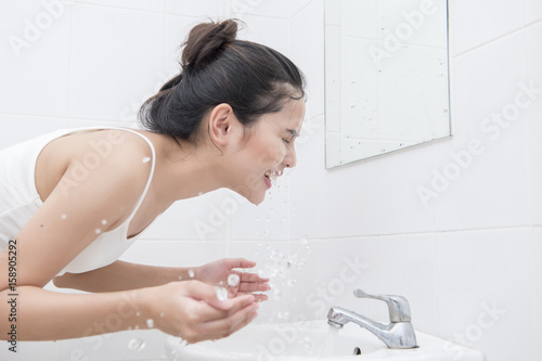 Beautiful asian woman is washing her face