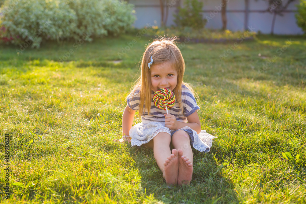 Funny child with candy lollipop, happy little girl eating big sugar lollipop, kid eat sweets Funny child with candy lollipop, happy little girl eating big sugar lollipop, kid eat sweets