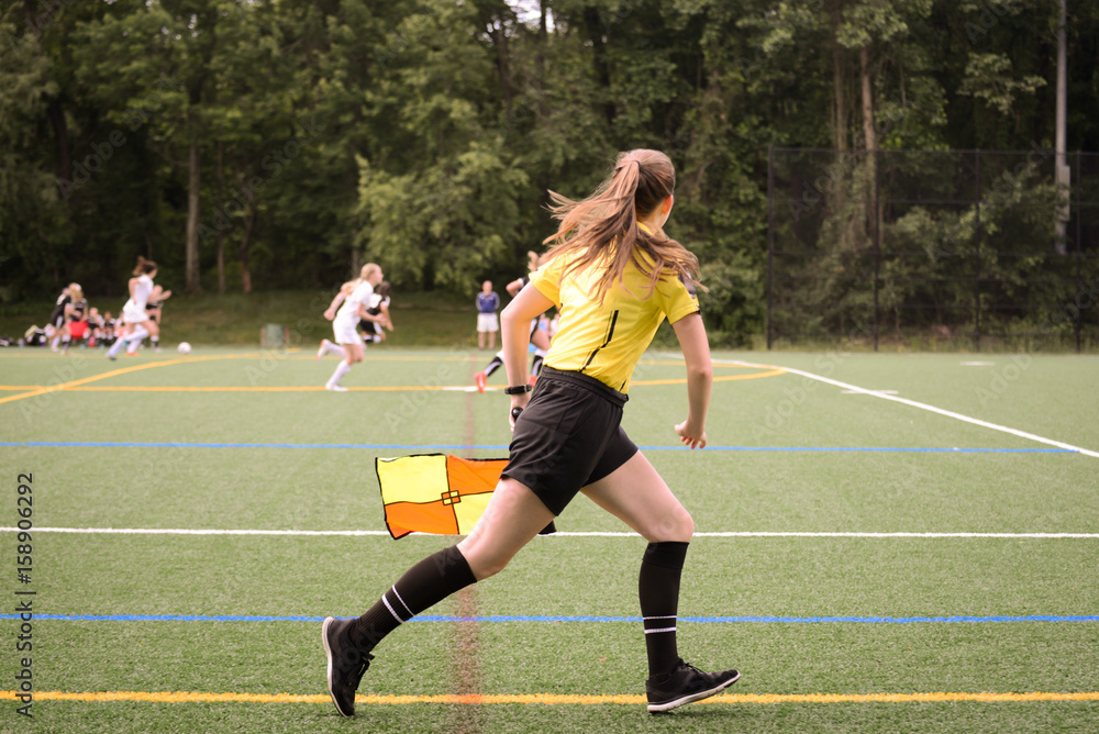 Naklejka premium Lineswoman running along the sideline