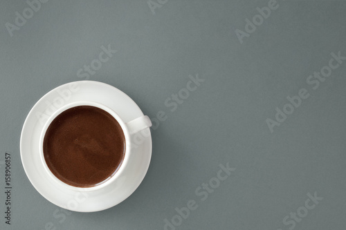 Coffee in white cup on gray background.
