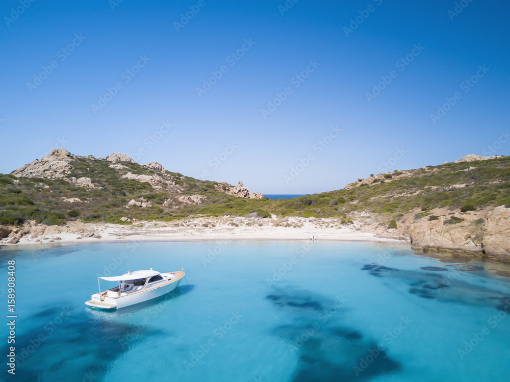 Obraz premium Aerial view of a sail boat in front of Mortorio island in Sardinia. Amazing beach with a turquoise and transparent sea. Emerald Coast, Sardinia, Italy...