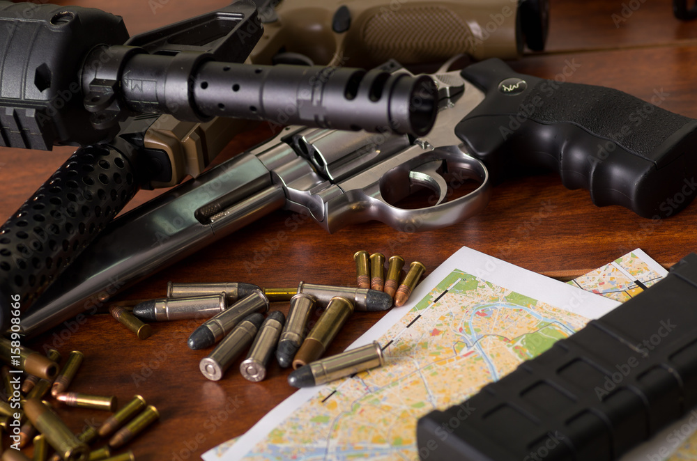 Obraz premium Bullets and a firearm. Bullets are a projectile expelled from the barrel of a firearm over a map, on wooden table