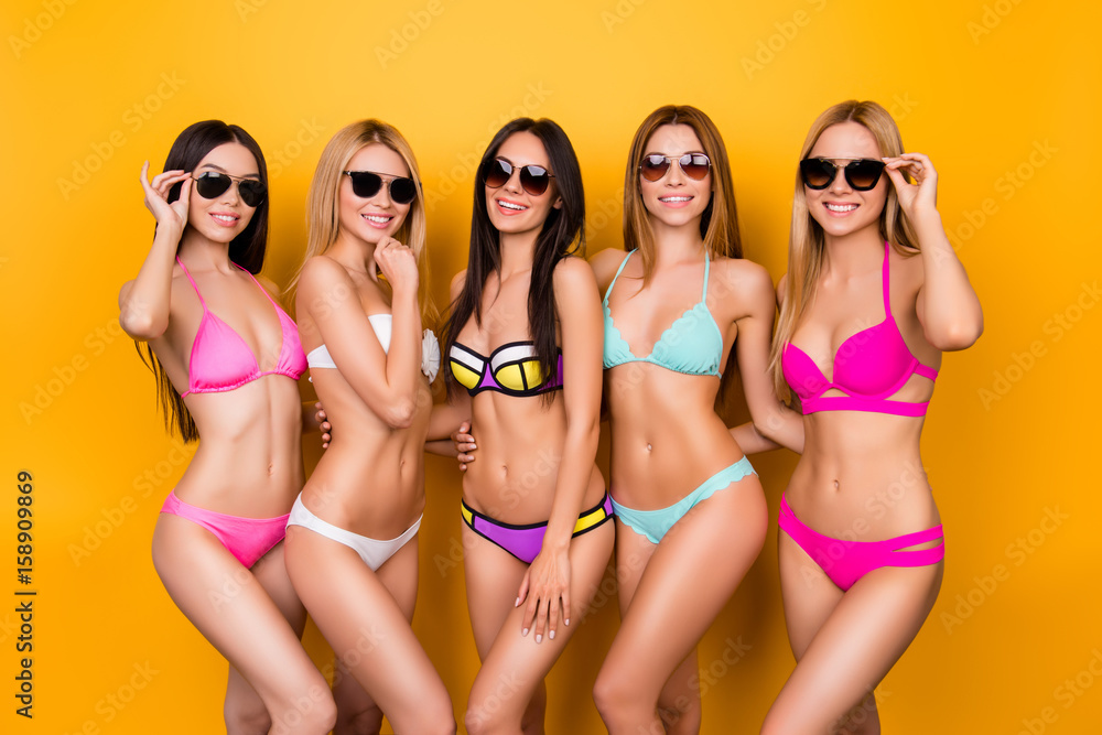 Hot brunette, blond and brown-haired girls are posing in colorful, trendy, fashionable swimming suits and sunglasses, they are chilling out near the pool in summer on a bachelorette hen party Hot brunette, blond and brown-haired girls are posing in colorful, trendy, fashionable swimming suits and sunglasses, they are chilling out near the pool in summer on a bachelorette hen party