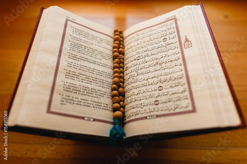 Quran and tesbih beside window in old brown interior