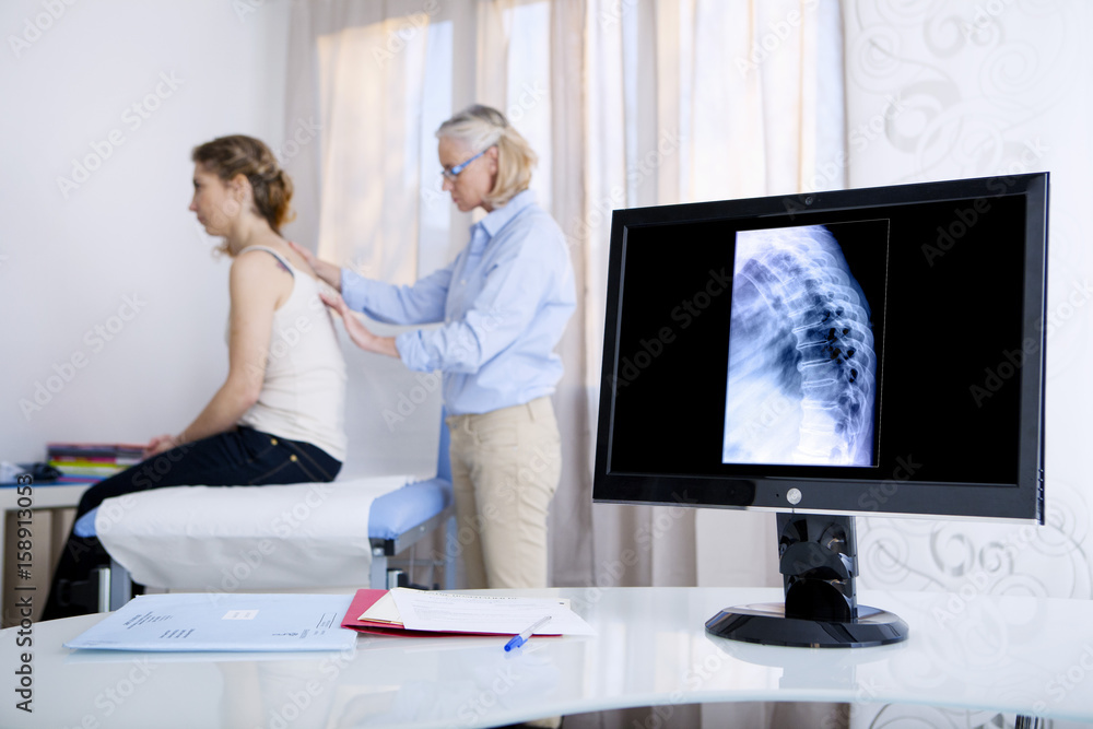 Obraz premium Doctor examining patient's back