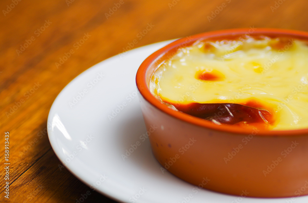 Close up of a Turkish traditional dairy style rice pudding sutlac served in a crock on wooden table Close up of a Turkish traditional dairy style rice pudding sutlac served in a crock on wooden table