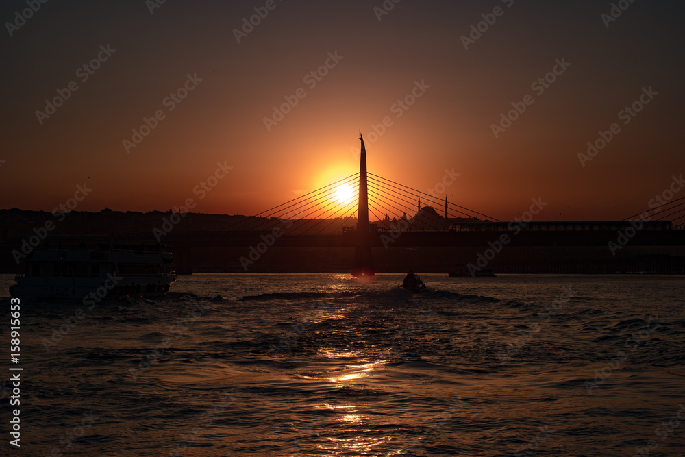 Sunset in Istanbul with sun going behind the bridge