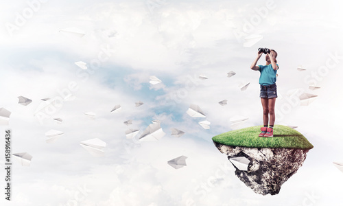 Photography Concept of careless happy childhood with girl looking in binocul