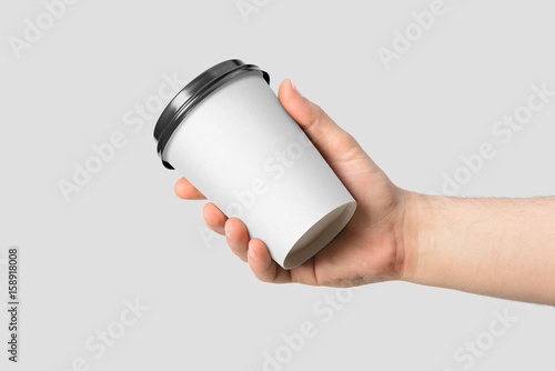 Fotografia Mockup of male hand holding a Coffee paper cup isolated on light grey background