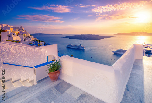 Canvas Print Amazing evening view of Fira, caldera, volcano of Santorini, Greece with cruise ships at sunset