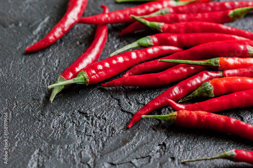 cooking sauce with red chili pepper on dark kitchen table background close up