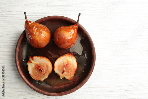 Baked pears with syrup served in wooden plate