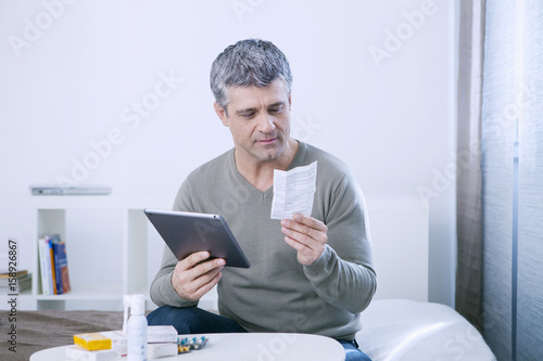 Man reading medication instruction sheet