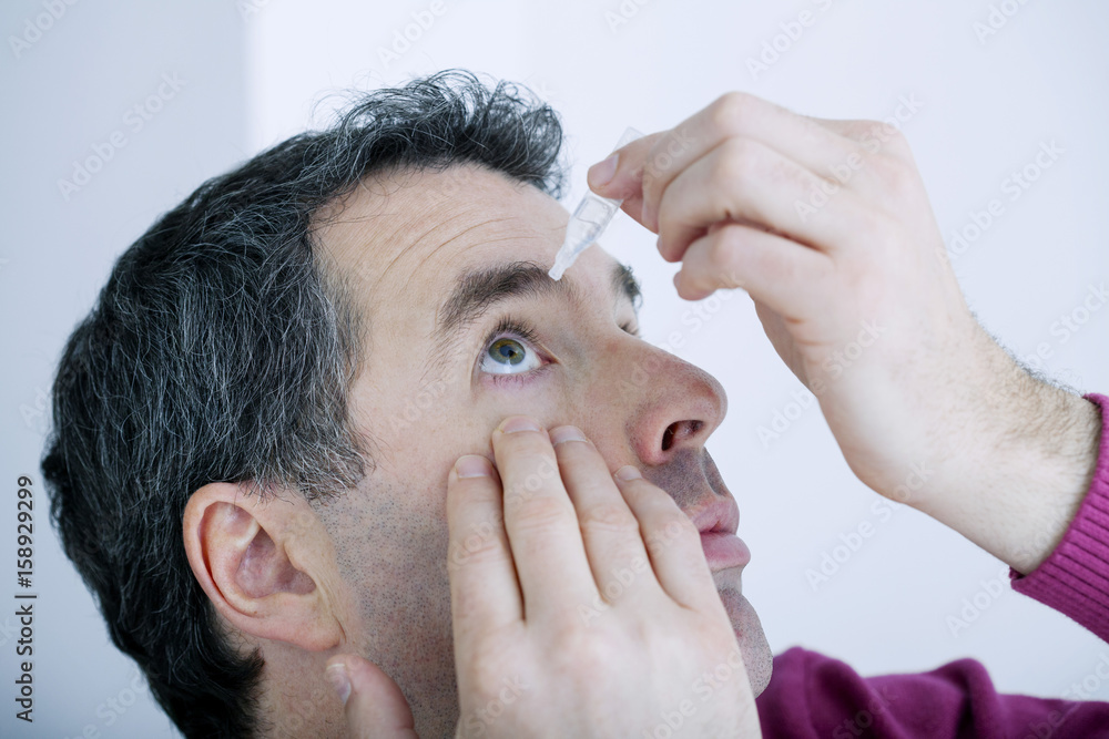Fototapeta premium Man using eye drops