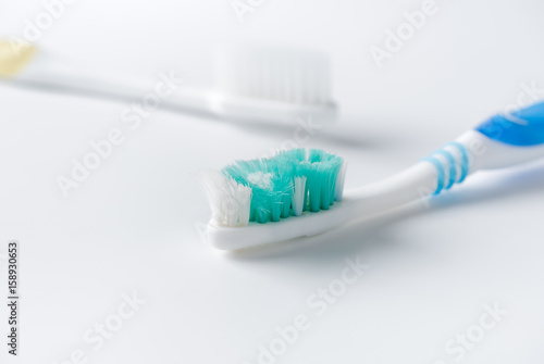 Used toothbrush and new toothbrush on white background