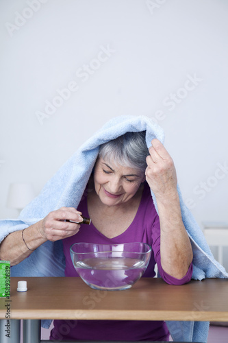 Senior woman preparing inhalation with essential oil