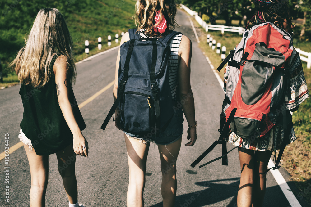 Diverse Backpacker Women Walking along The Street Side Diverse Backpacker Women Walking along The Street Side