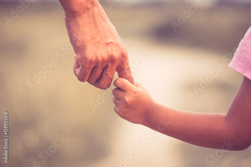 Father and daughter holding hand together in vintage color tone © pingpao