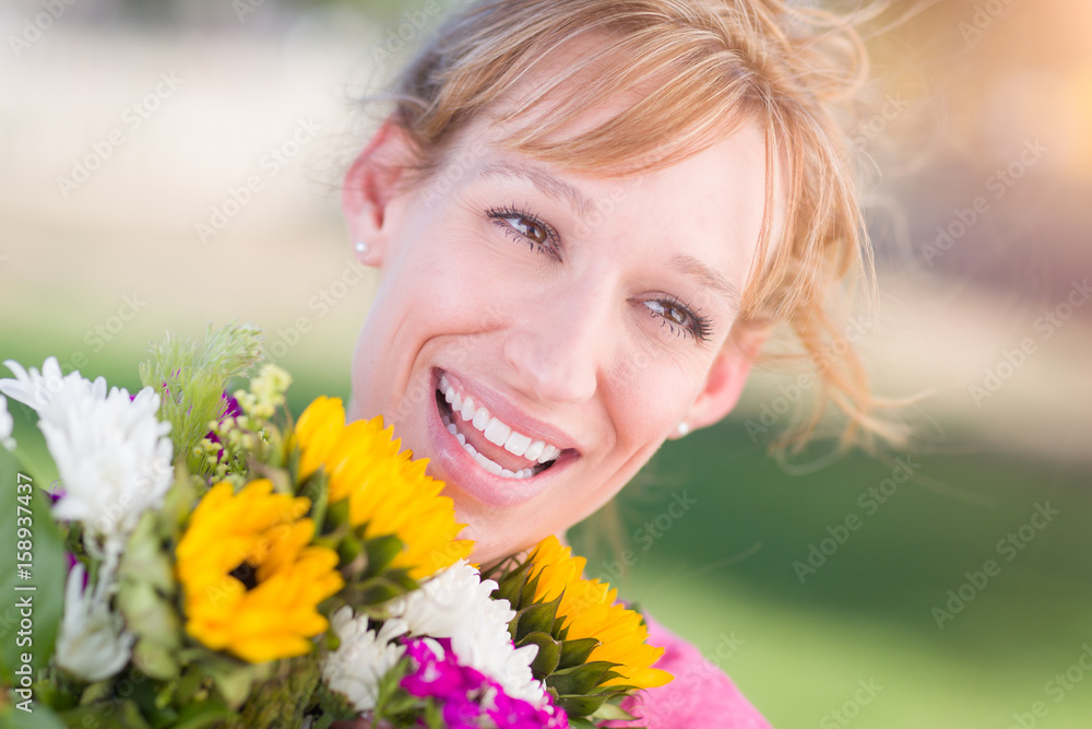 Outdoor Portrait of an Excited Young Adult Brown Eyed Woman Holding a Bouquet of Flowers. Outdoor Portrait of an Excited Young Adult Brown Eyed Woman Holding a Bouquet of Flowers.