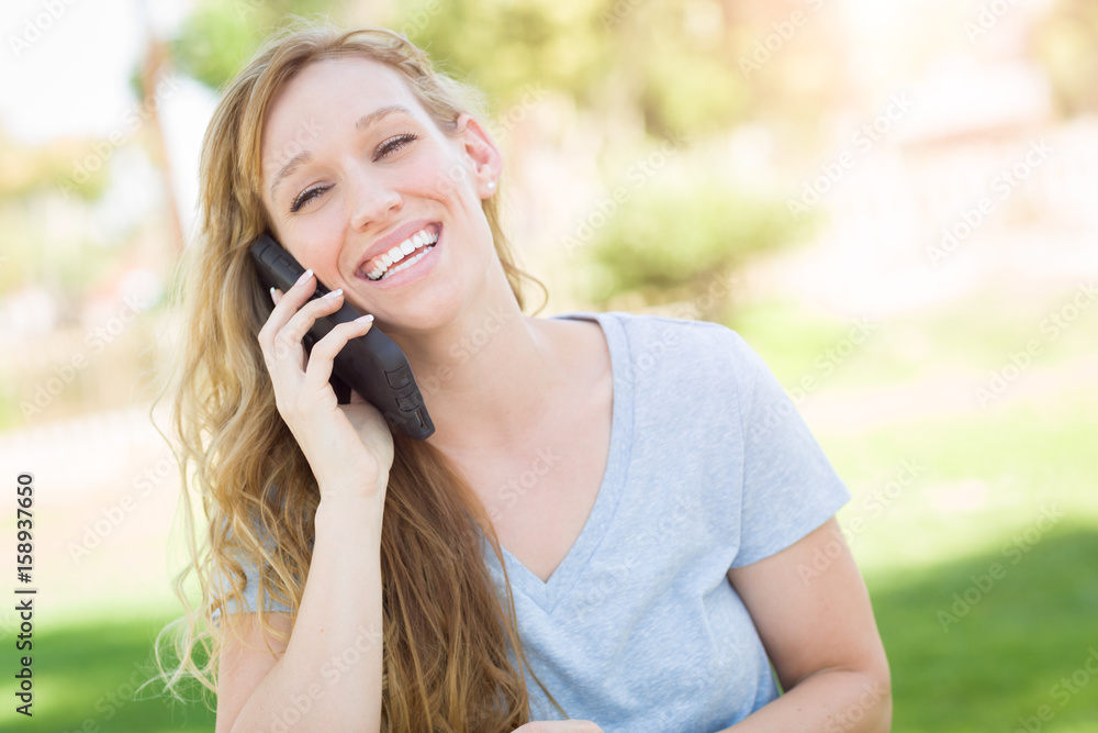 Young Adult Woman Outdoors Talking on Her Smart Phone. Young Adult Woman Outdoors Talking on Her Smart Phone.