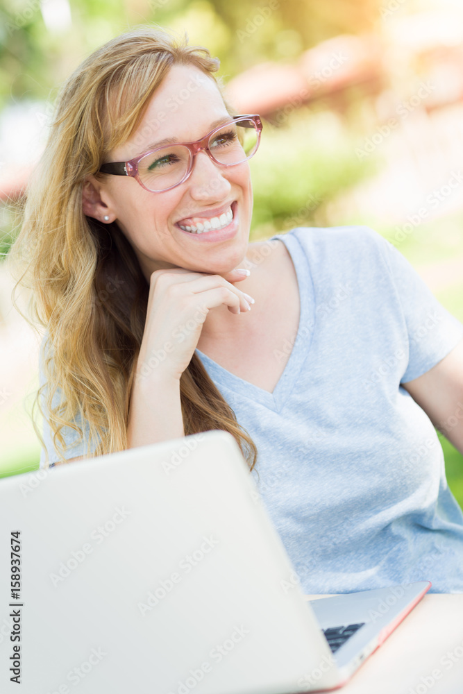 Young Adult Woman Wearing Glasses Outdoors Using Her Laptop. Young Adult Woman Wearing Glasses Outdoors Using Her Laptop.