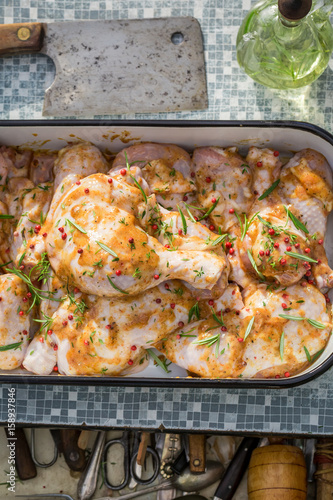 Seasoning chicken legs in the summer garden for grill