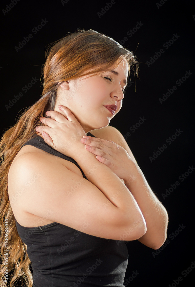 Beautiful young lady Suffer crick after workout in a black background Beautiful young lady Suffer crick after workout in a black background