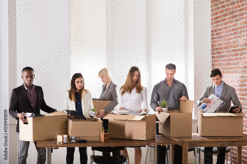 Foto Businesspeople Packing Belongings In Cardboard Box
