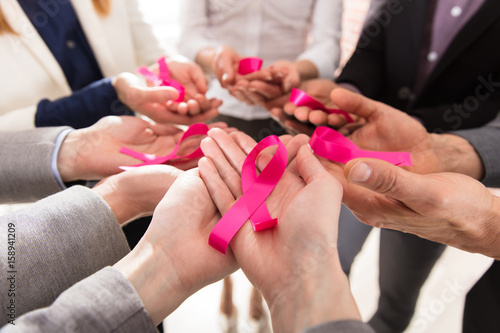 Businesspeople Showing Pink Ribbon In Their Hands