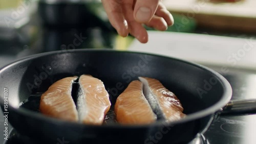 Close-up of Hands Putting Piece of Red Fish Fillet on a Hot Pan