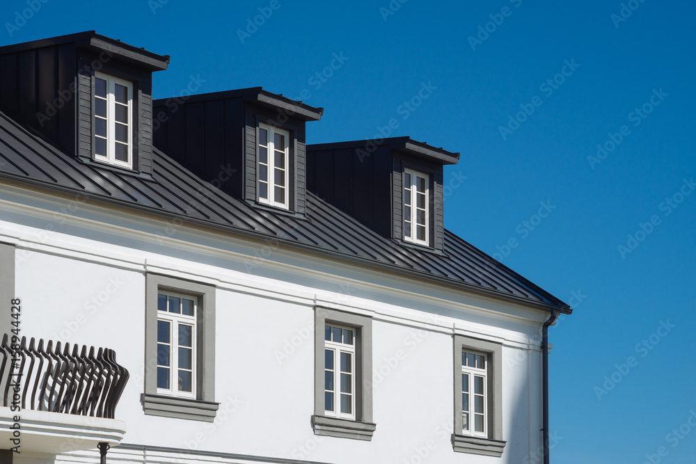 Top of residential house facade against blue sky Top of residential house facade against blue sky