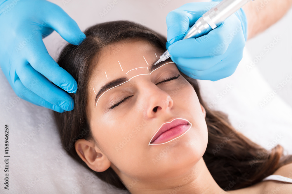 Cosmetologist Applying Permanent Make Up On Eyebrows Cosmetologist Applying Permanent Make Up On Eyebrows