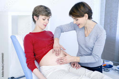 Doctor examining a pregnant woman's abdomen