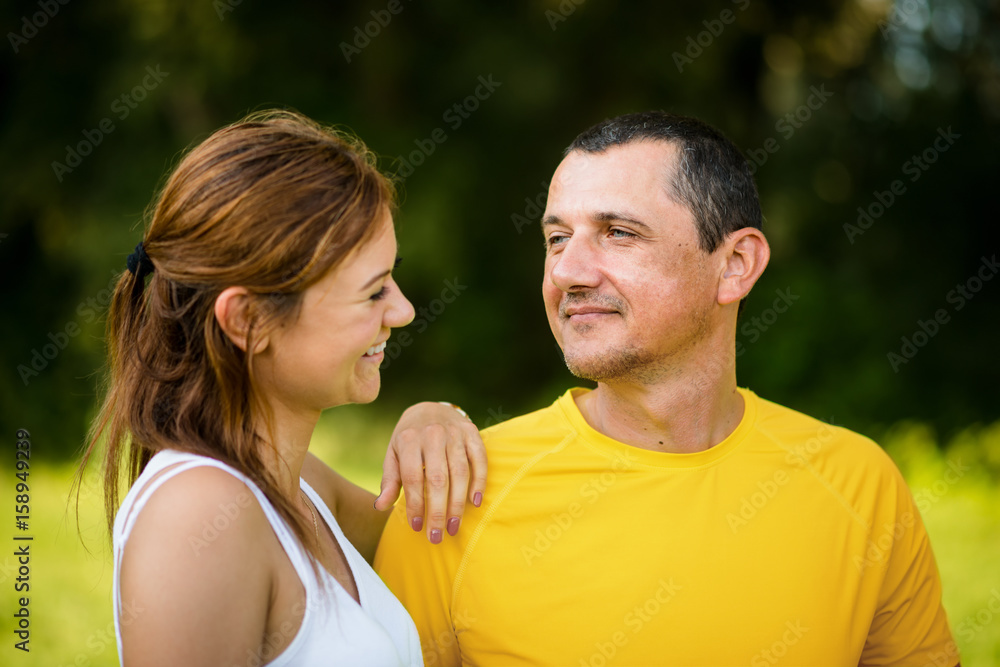 Mature father with adult daughter outdoors.