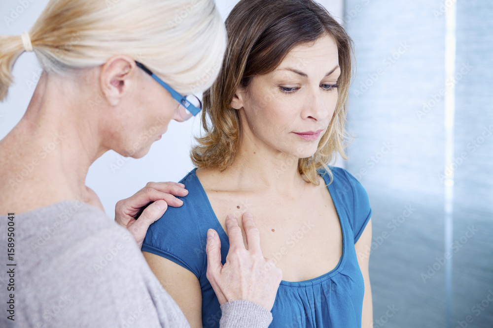 Doctor examining the upper chest of a patient Doctor examining the upper chest of a patient