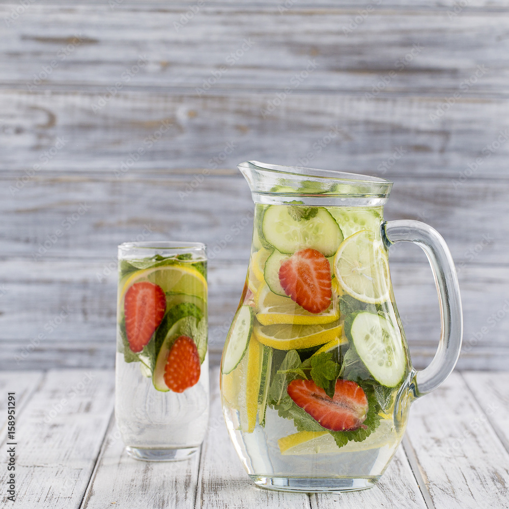 Dietary detox drink with lemon juice, red strawberry, cucumber and mint leaves in clear water with ice. Dietary detox drink with lemon juice, red strawberry, cucumber and mint leaves in clear water with ice.