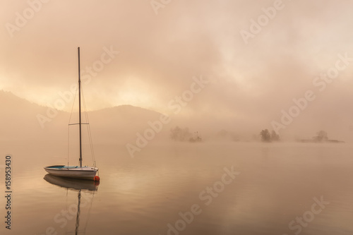 boat on a misty morning on the lake