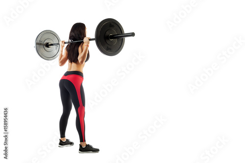 Young sportive woman fitness model brunette makes a squat with a barbell on white isolated background, Standing position