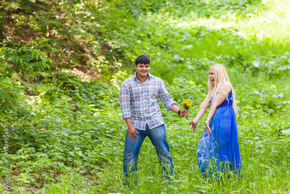 Young man giving a flower dandelion to girlfriend outdoors Young man giving a flower dandelion to girlfriend outdoors