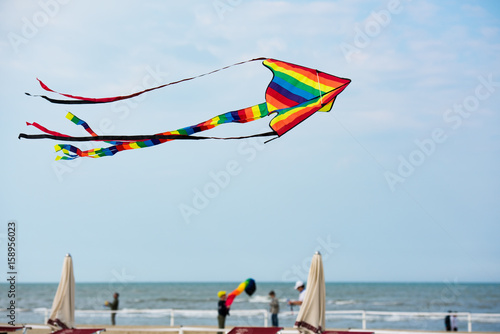 Rainbow kite flying over the beach
