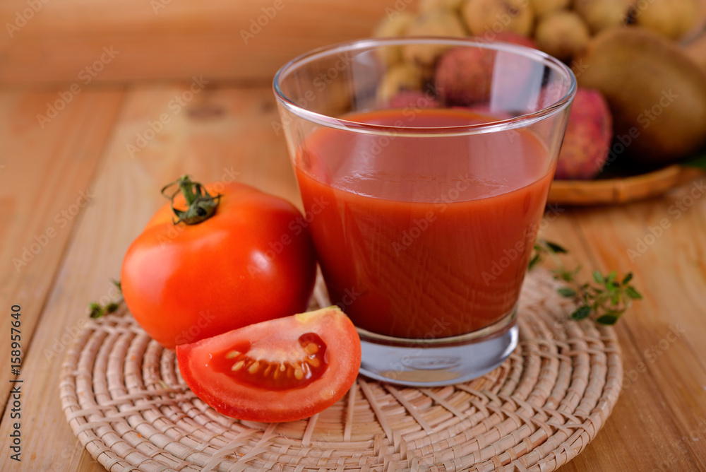 a glass of tomato juice with fresh tomato on wooden table a glass of tomato juice with fresh tomato on wooden table