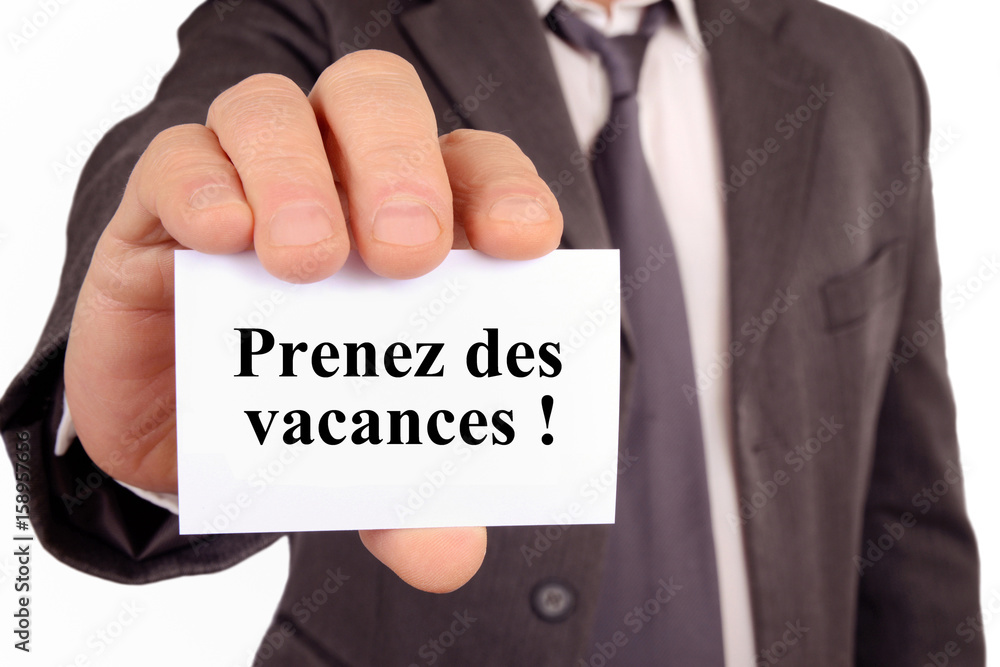 Homme tenant une carte avec prenez des vacances écrit dessus Homme tenant une carte avec prenez des vacances écrit dessus