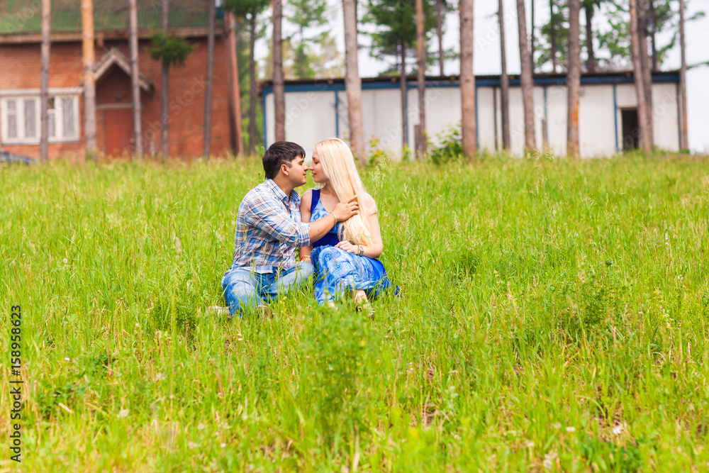 Happy young couple relaxing on the lawn in a summer park. Love concept. Vacation. Happy young couple relaxing on the lawn in a summer park. Love concept. Vacation.