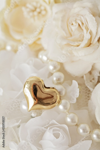 wedding decoration with golden heart, bridal pearls and flowers