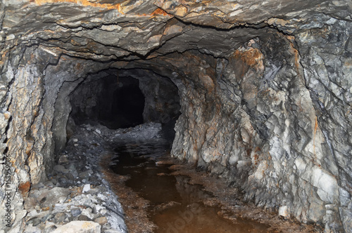 an abandoned mine tunnel in the mountains, stone catacombs. In an abandoned water tunnel