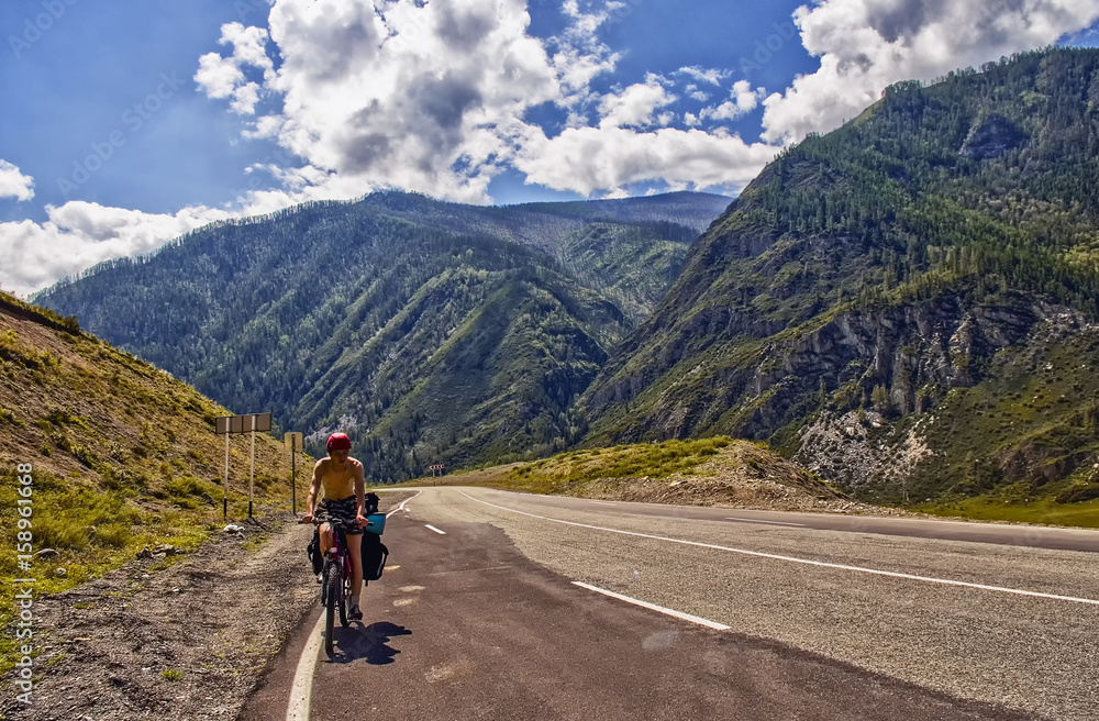 Chuiski road, Altai Republic. The road in the mountains, highway, paved road near the shore of the river Chuya. Sunny day in summer. Biking, cycling, cyclist.