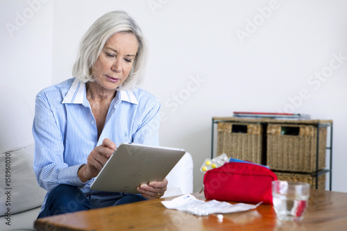 Senior woman reading medical informations on the internet