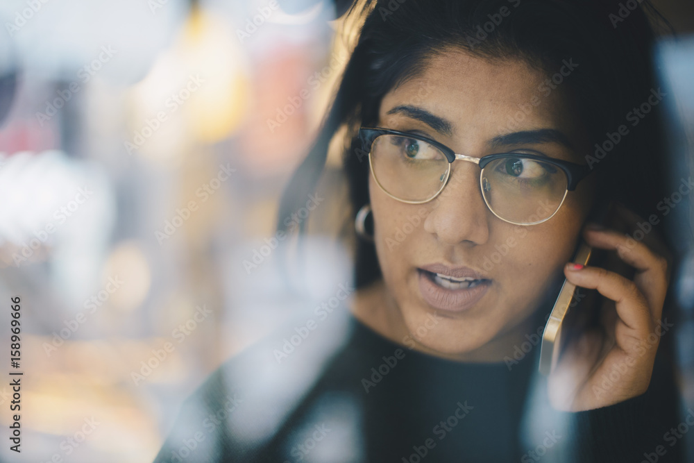 Businesswoman looking away while using smart phone seen through glass Businesswoman looking away while using smart phone seen through glass