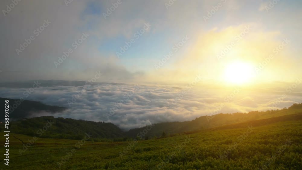 Brilliant summit dawn above flowing cloud waves, red sun disk time lapse Brilliant summit dawn above flowing cloud waves, red sun disk time lapse